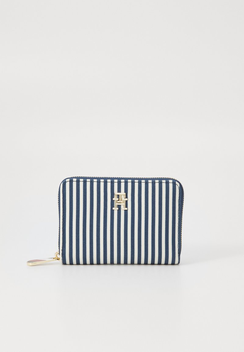Zippered wallet featuring navy and white stripes, gold hardware, and a prominent logo on the front. Compact and rectangular design.