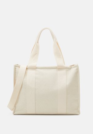 Saco de tote em lona na cor off-white com alças duplas em tecido, design estruturado, detalhes em tiras contrastantes e costuras robustas. Sem acessórios metálicos visíveis.