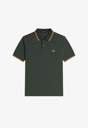 Camiseta polo de color verde oscuro con cuello y mangas a rayas amarillas, tapeta de dos botones y pequeño emblema bordado en el pecho. Material de algodón.