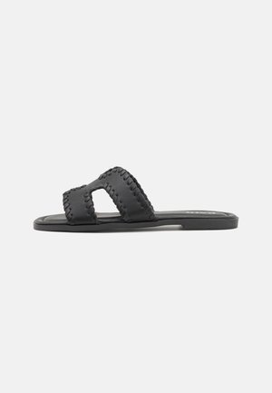 Sorte slidesandaler med to brede remme med vævet tekstur og udskåret design. Flad sål med en glat finish.