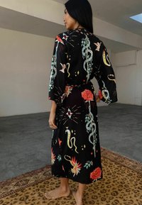 Melns kimono stila halāts ar krāsainiem ziedu un čūsku rakstiem, ar plašām piedurknēm un saistītu jostu. Gluda auduma, garums līdz potītēm.