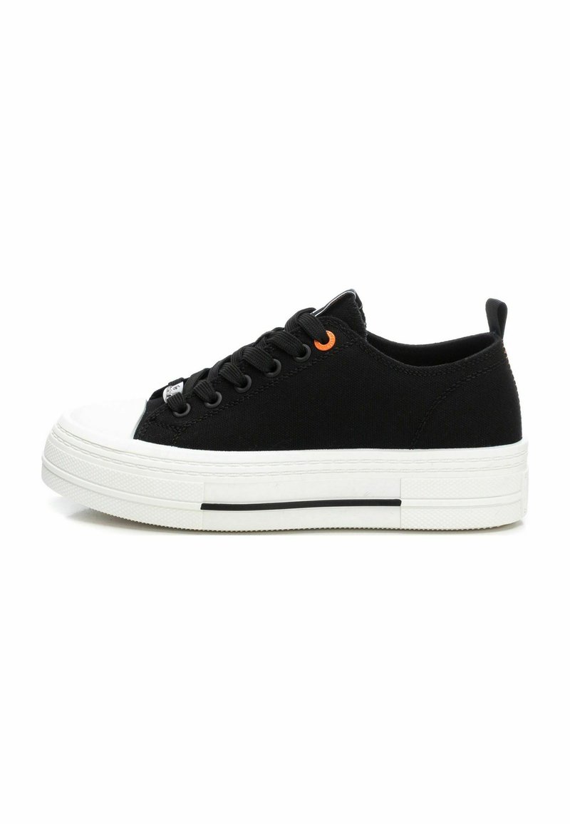 Zapatillas de lona negras con una suela de goma blanca, que presentan cordones negros, un acento en ojal naranja y una puntera texturizada.