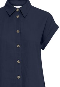 Tumesinine lühikeste varrukatega särk, millel on nööpidega esikinnitus, ümardatud metallist nööbid ja struktureeritud krae. Pehme, kerge kangas.