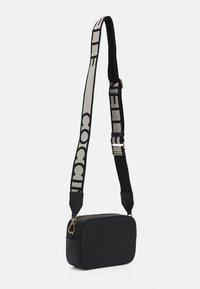 Černá kožená kabelka přes rameno s obdélníkovým tvarem. Má široký tkaný popruh s nápisem, zlaté kovové prvky a zipové zapínání.