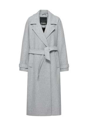 Manteau long en laine gris clair avec larges revers, ceinture nouée à la taille, brides aux poignets et deux poches avant, présenté sur un cintre.