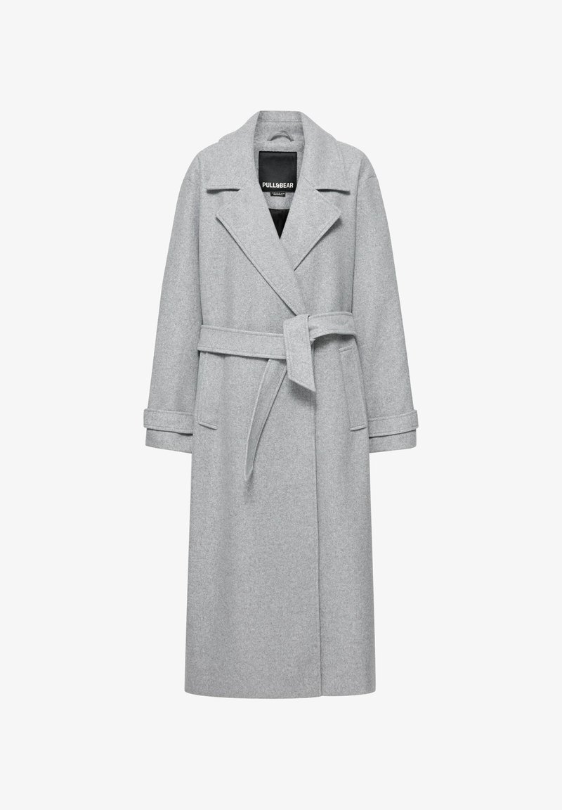 Manteau long en laine gris clair avec larges revers, ceinture nouée à la taille, brides aux poignets et deux poches avant, présenté sur un cintre.