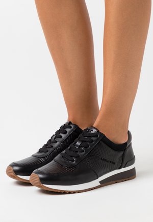 Baskets en cuir noir avec panneaux texturés, bout rond et lacets noirs. Présentent une semelle intermédiaire blanche et une semelle extérieure en caoutchouc marron.