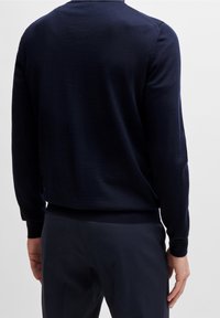 Laivastonsininen kevyt neulepusero, jossa pyöreä pääntie, pitkät hihat sekä resorit hihansuissa ja helmassa. Sileä pinta, vähäinen saumaus.