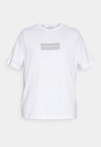 Camiseta de algodón blanca con cuello redondo, mangas cortas y un logotipo rectangular gris impreso en el frente. Diseño simple, corte casual.