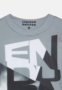 Grå grafisk t-shirt med texten "Limited Edition", rund hals och en geometrisk design i nyanser av grått med vita accenter.