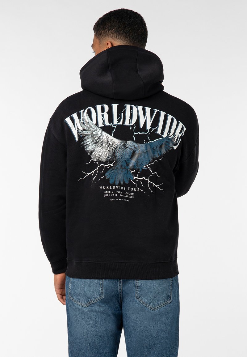 Schwarzer Hoodie mit einer großen Grafik eines Adlers und dem Wort "WORLDWIDE" in Weiß, versehen mit Blitzmotiven. Rippbündchen und -saum.