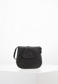 Svart axelremsväska i texturerat läder, med en klaffstängning med en rund tryckknapp och en tunn justerbar rem.