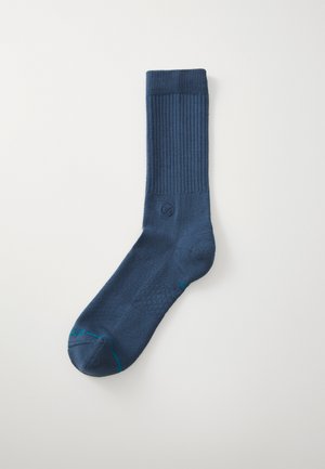 Navy blue sock with ribbed cuff, smooth texture, reinforced toe, and contrasting light blue stitching detail.