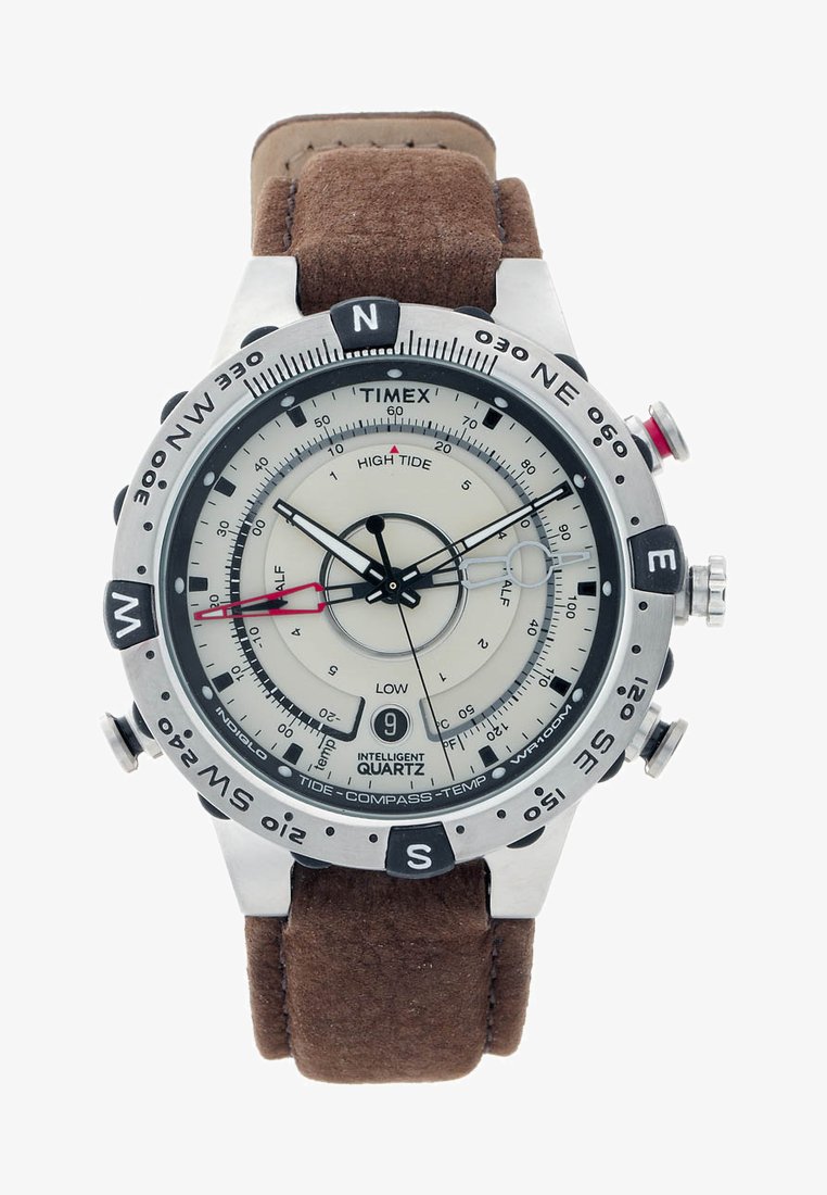 Montre Timex avec un boîtier en acier inoxydable, cadran crème et marquages noirs. Bracelet en cuir brun avec fermoir. Fonctionnalités de marées, compas et température.