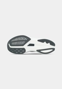 Semelle de chaussure de sport avec un empeigne blanche, traction en caoutchouc noir avec des rainures et des motifs circulaires, et une surface texturée pour une meilleure adhérence.