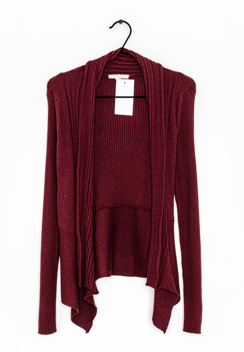 Cardigan bordeaux en tricot côtelé à manches longues, ouvert sur le devant, suspendu sur un cintre noir, avec un ourlet drapé et une étiquette blanche vierge.