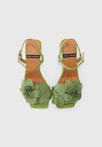 Sandali con tacco blocco verdi a fantasia floreale, caratterizzati da cinturini, fiori texturizzati e una soletta in pelle. Finitura liscia con accenti decorativi.
