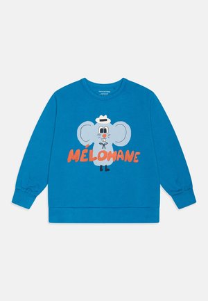 Sweat-shirt bleu en coton, orné d'un graphique d'éléphant en dessin animé bleu clair avec le mot "MÉLOMANE" en orange. Manches longues avec poignets côtelés.