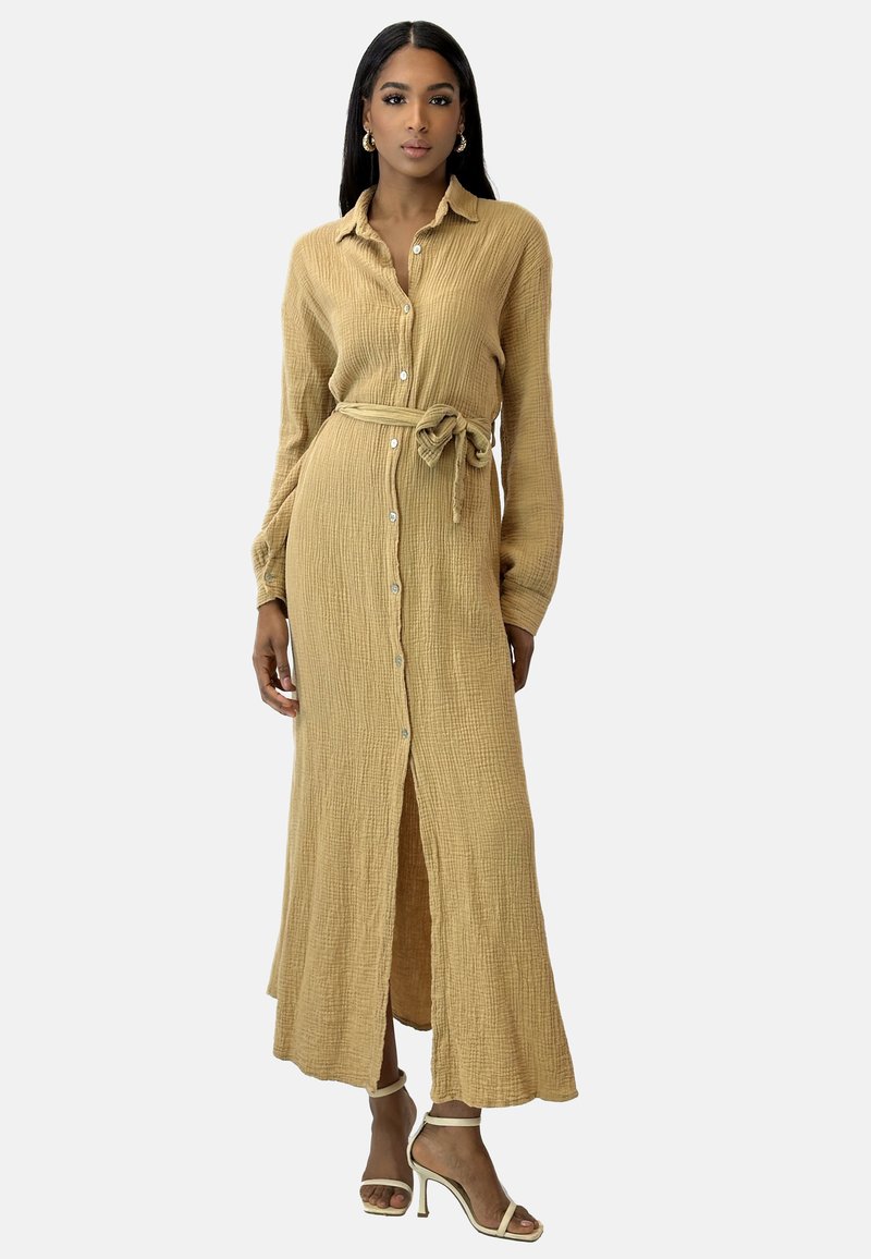 Długa, zapinana na guziki sukienka koszulowa z teksturowanej, jasnobrązowej tkaniny, z paskiem w talii, długimi rękawami i rozcięciem z przodu.