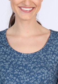 Blaues, blumendesigntes Stoffmaterial mit Rundhalsausschnitt und kurzen Ärmeln. Das Design zeigt kleine, hellblaue Blumen auf einem dunkelblauen Hintergrund.