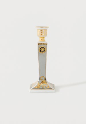 Candeliere decorativo bianco e oro con base quadrata, motivi ornati in foglia d'oro e un emblema di Medusa sul gambo.