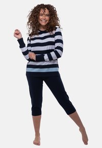 Raidallinen pitkähihainen paita tummansinisessä, vaaleansinisessä ja valkoisessa; yhdistettynä tummansinisiin kappaleisiin. Pehmeä materiaali, rento muotoilu ja istuvat hihansuut.