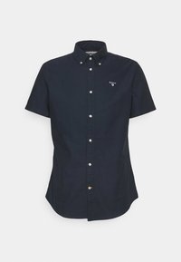 Granatowa koszula z krótkim rękawem zapinana na guziki, wykonana z bawełny. Posiada kołnierzyk, zapięcie na guziki z przodu oraz małe logo na lewej piersi. Gładka struktura.
