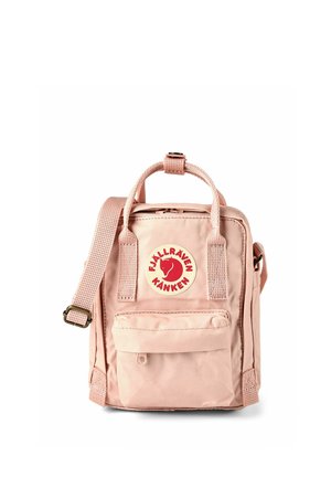 Zaino Fjällräven Kånken rosa chiaro con manici superiori, tracolla regolabile, tasca frontale con cerniera e patch logo rotondo rosso su sfondo bianco.