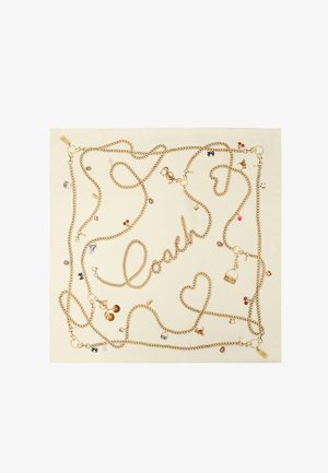 Sciarpa color crema con catene dorate che formano la scritta "Coach" e cuori, decorata con piccoli charm come ciliegie, borse e dadi.