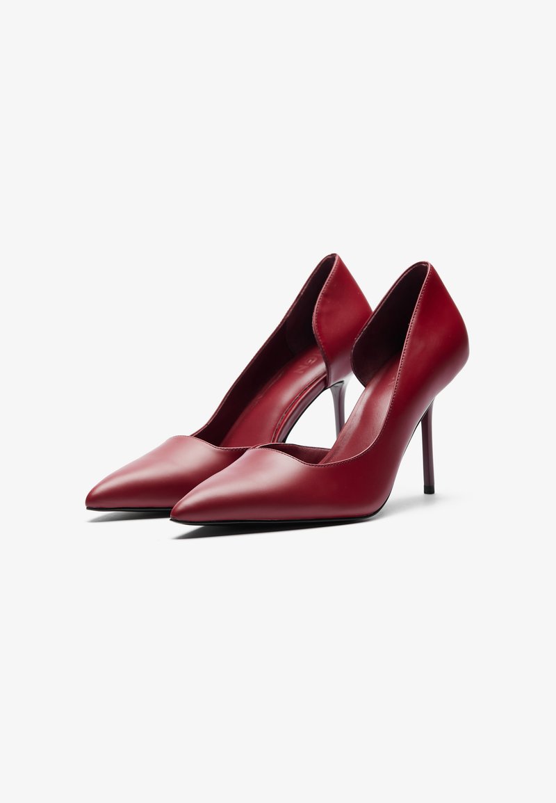 Décolleté rossi in pelle con tacco alto, punta affusolata e lati aperti, caratterizzati da una silhouette elegante e un tacco a spillo sottile.