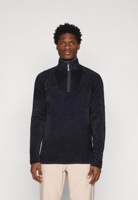 Fleece-pullover i mörkgrått med halvdragkedja, strukturerad yta, långa ärmar och sidokilar för ökad rörelsefrihet.