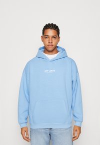 Felpa con cappuccio blu chiaro, realizzata in tessuto morbido, con tasca frontale e testo bianco "OFF LIMITS". Vestibilità comoda con cappuccio regolabile.