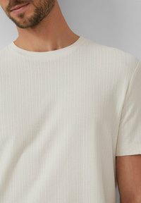 Witte textuur korte mouwen t-shirt met een geribbeld patroon en een klassieke ronde hals. De stof lijkt glad en licht van gewicht.
