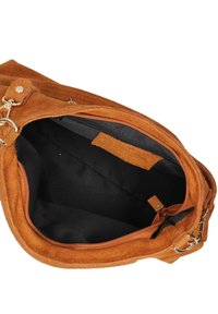 Suède handtas in bruin met een ritssluiting. De binnenkant is van zwart stof met een zijvak met rits en een patch voor organisatie.