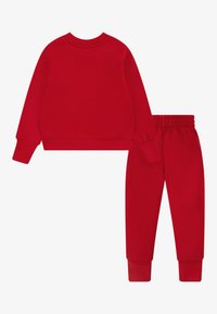 Sweatshirt de algodão vermelho e calças correspondentes. O sweatshirt tem mangas longas e um decote redondo. As calças têm uma cintura elástica e punhos.