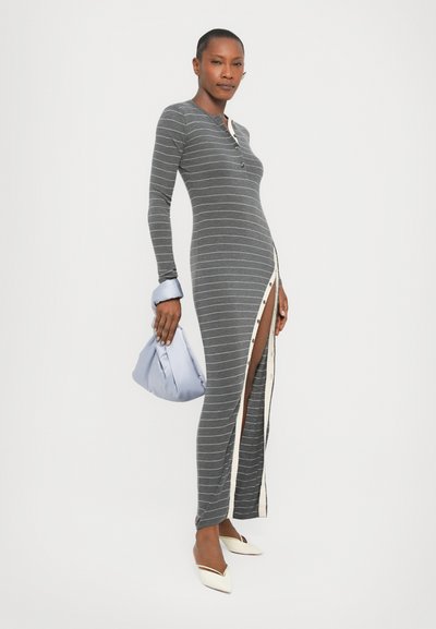 Gray striped long-sleeve dress with buttons and a side slit, paired with a light blue bag and white pointed flats. Smooth texture, fitted design.