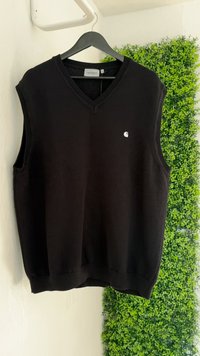 Schwarzer gestrickter ärmelloser Pullover mit V-Ausschnitt und gerippten Kanten. Verfügt über ein kleines weißes Logo auf der Vorderseite. H�ängt an einem schwarzen Kleiderbügel.