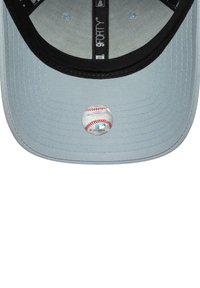 Gray baseball cap with a black brim. Features a circular patch resembling a baseball on the front. Textured fabric surface.
