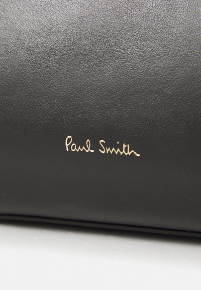 Must mustribuurt, millel on sile tekstuur ja kuldne pitsak "Paul Smith" allkirja. Lihtne, ristkülikukujuline disain ilma täiendavate kaunistusteta.