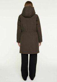 Bruine gevoerde jas met een capuchon, cinched taille, lange mouwen en zijzakken. De achterkant heeft een gladde textuur en een getailleerde pasvorm.