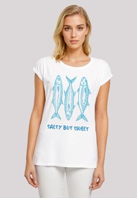 White cotton t-shirt featuring a blue graphic of three fish above the text "SALTY BUT SWEET," with rolled sleeves and a relaxed fit.