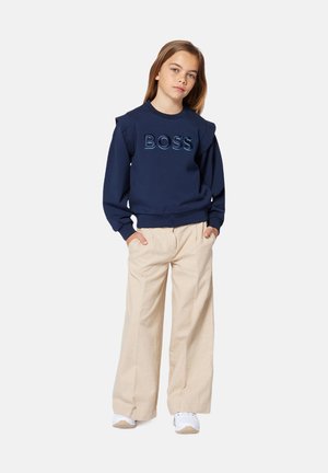 Sweatshirt bleu marine avec le logo "BOSS", col côtelé et détail sur les épaules. Assorti à un pantalon large beige clair et des baskets blanches.