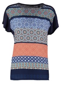 T-shirt med korte ærmer, der har et mix af geometriske mønstre i marineblå, koral og blå nuancer. Blødt stof med varierende teksturer og bånddesign.
