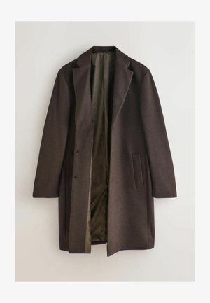 Mörkbrun ullrock med slitsad krage, två fickor fram och knäppning med knappar. Fodrad med ett texturerat innerfoder i olivgrönt.