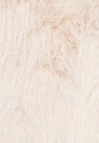 Valge kunstkarusnahk pikkade, pehmete kiududega, mis loob kohevuse ja kerge läike, andes luksusliku välimuse.