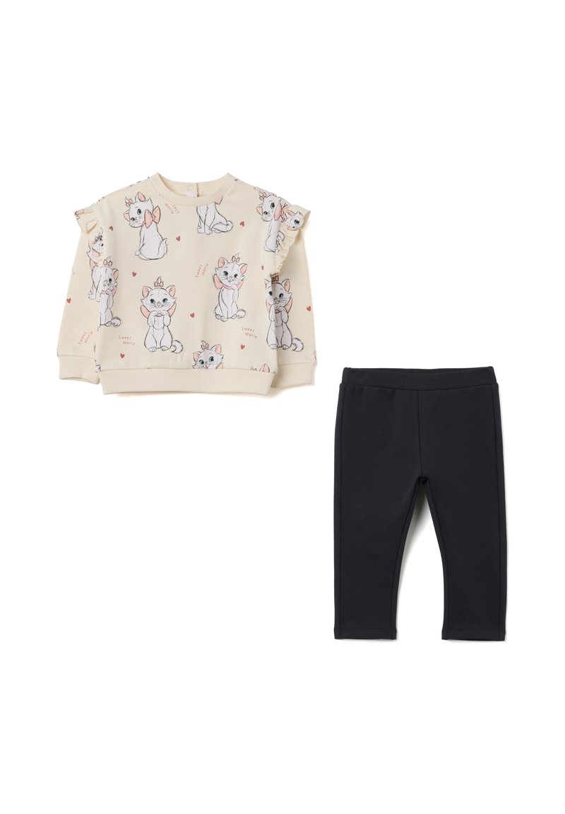 Sudadera beige claro con ilustraciones de gatos y mangas con volantes, combinada con leggings negros lisos. Ambos confeccionados con tela de algodón suave.