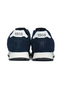 Sneakers in suede blu navy con accenti bianchi. Tra le caratteristiche ci sono la punta rotonda, il collare posteriore imbottito e la scritta "1968" stampata sul tallone.