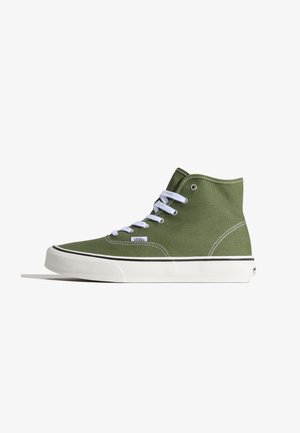 Baskets montantes Vans vert olive avec semelle en caoutchouc blanche, lacets blancs et coutures visibles, vues de côté sur un fond uni.