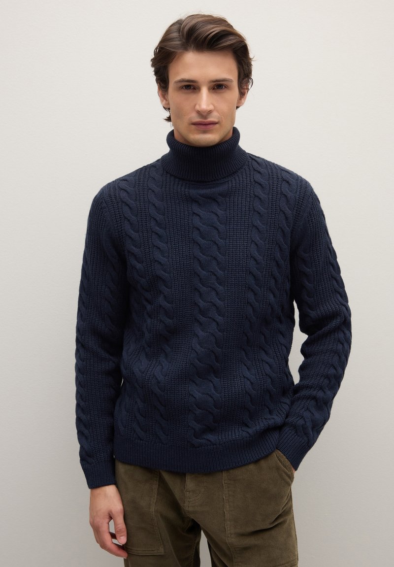 Marineblauer Rollkragenpullover mit Zopfmuster, der dicke Zöpfe und gerippte Details aufweist. Hergestellt aus strukturiertem Strickstoff, mit figurbetonter Silhouette.