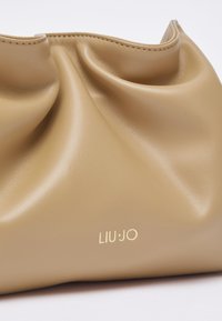 Weiche Clutch aus hellbraunem Leder mit dezenter Naht und kleinem goldfarbenem "LIU JO"-Logo in der Mitte auf der Vorderseite.